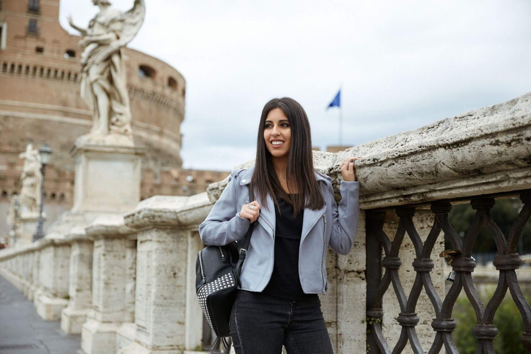 A female JCU student exploring Rome on a sunny day with a backpack.