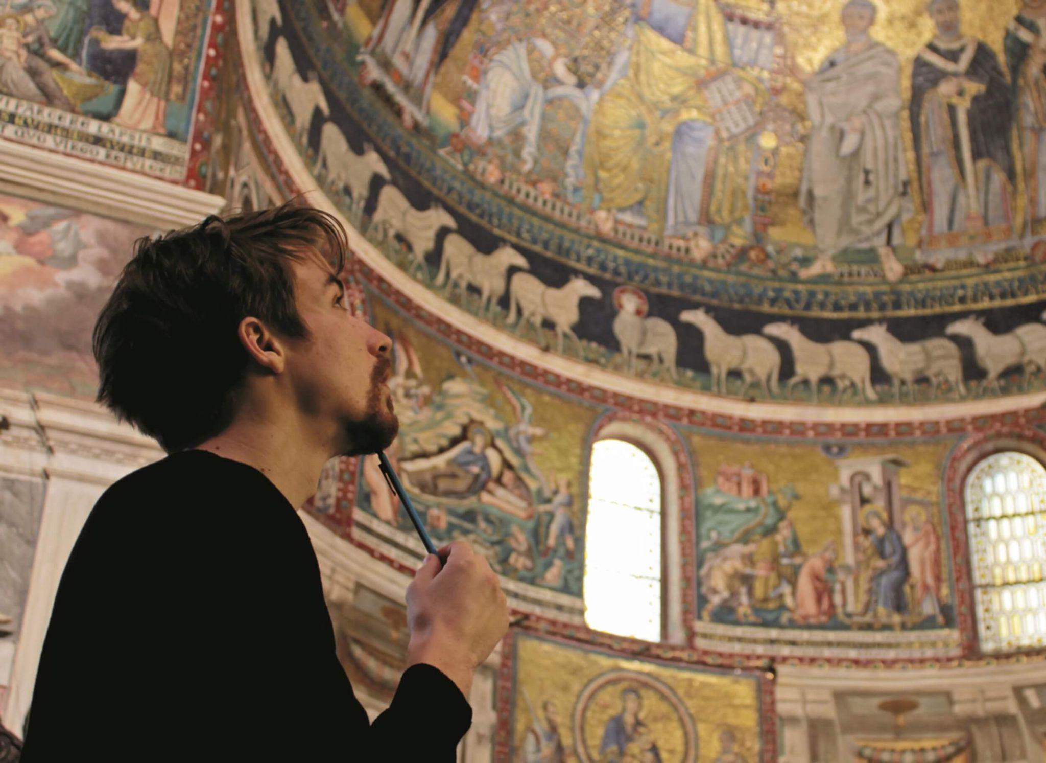 A student attending university in Rome analyzing a historical painted ceiling
