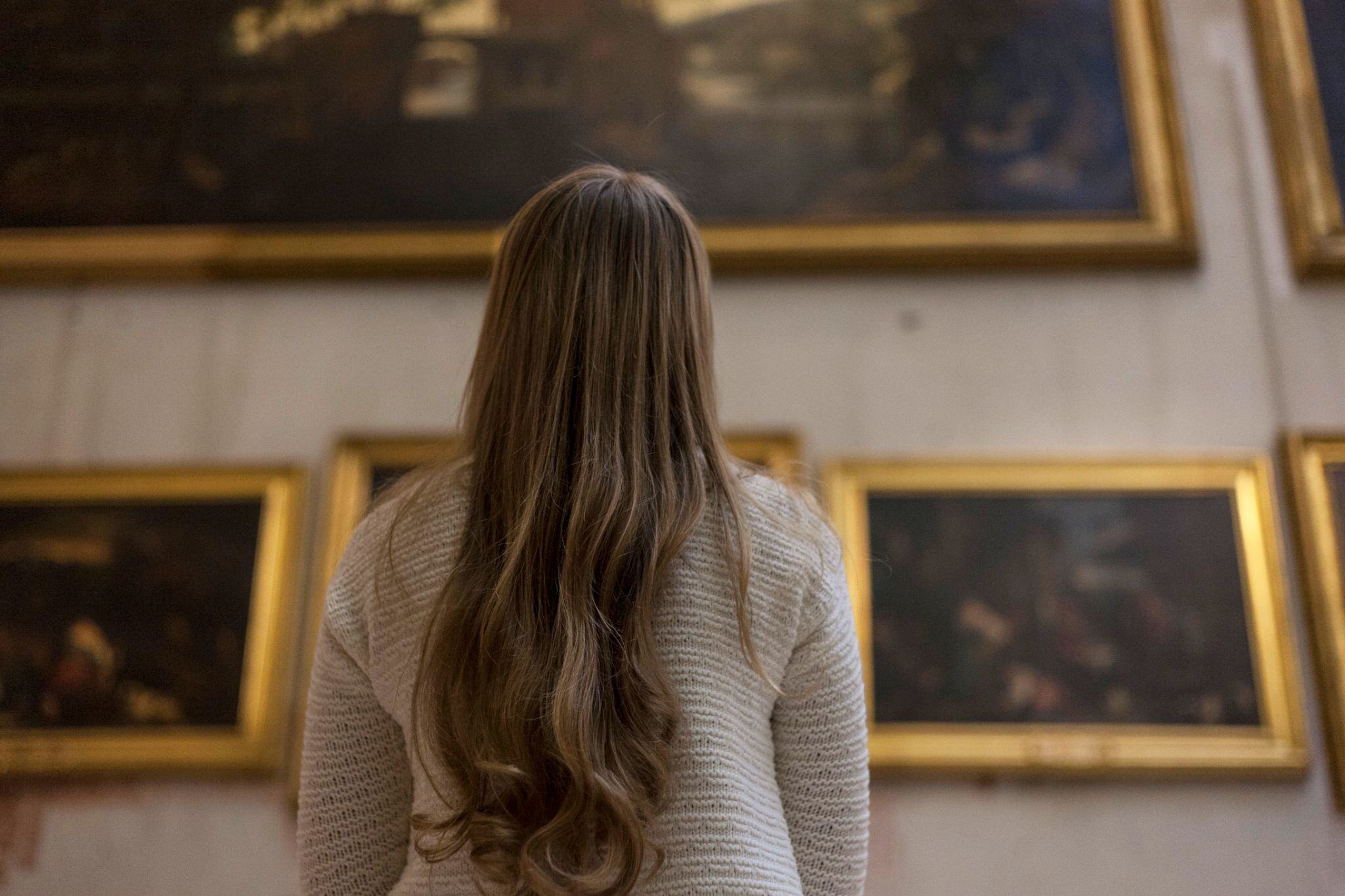 A female student examining an artistic work while on an outdoors educational trip at our university in Rome