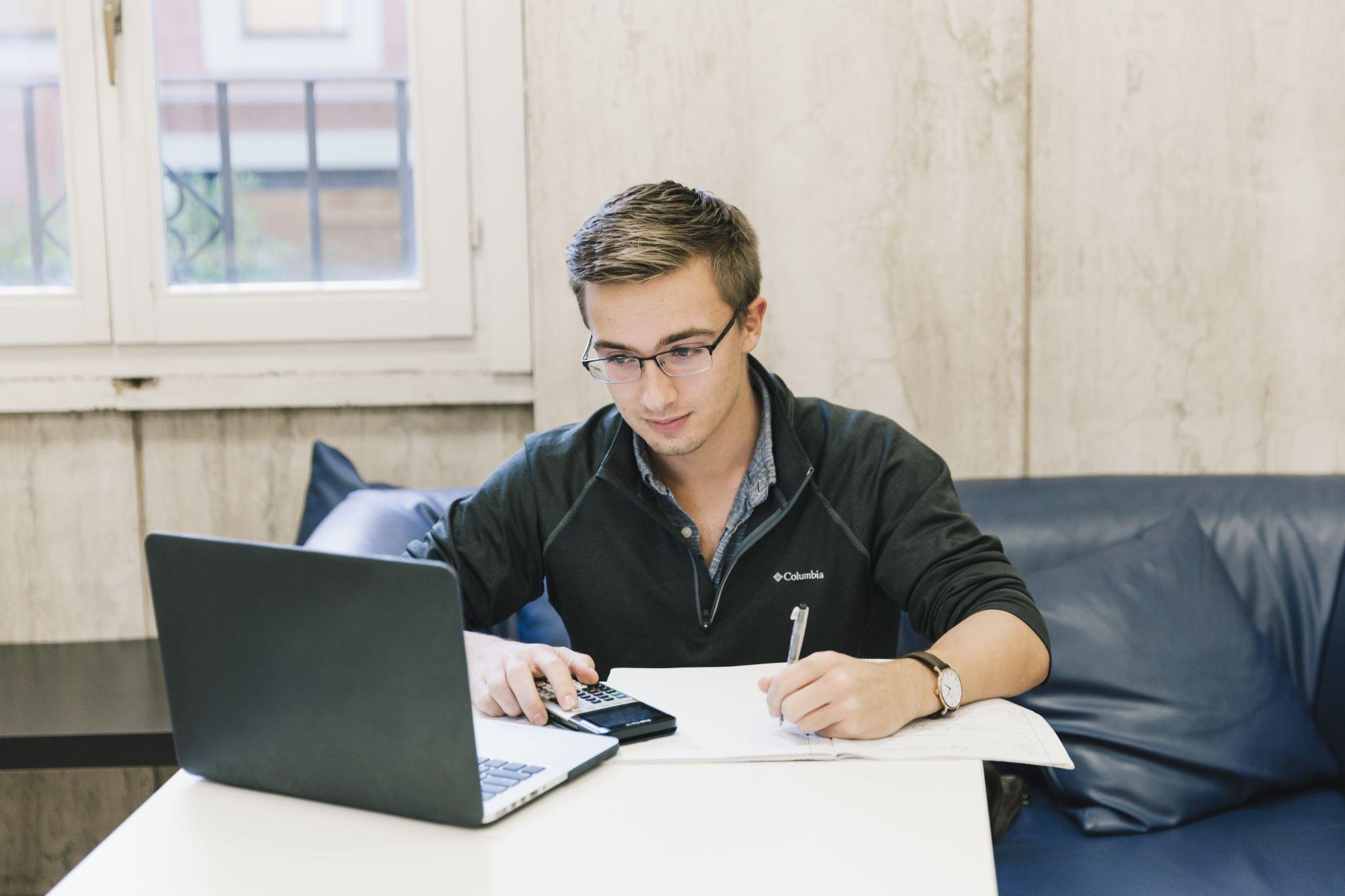 JCU student studying using a laptop and calculator