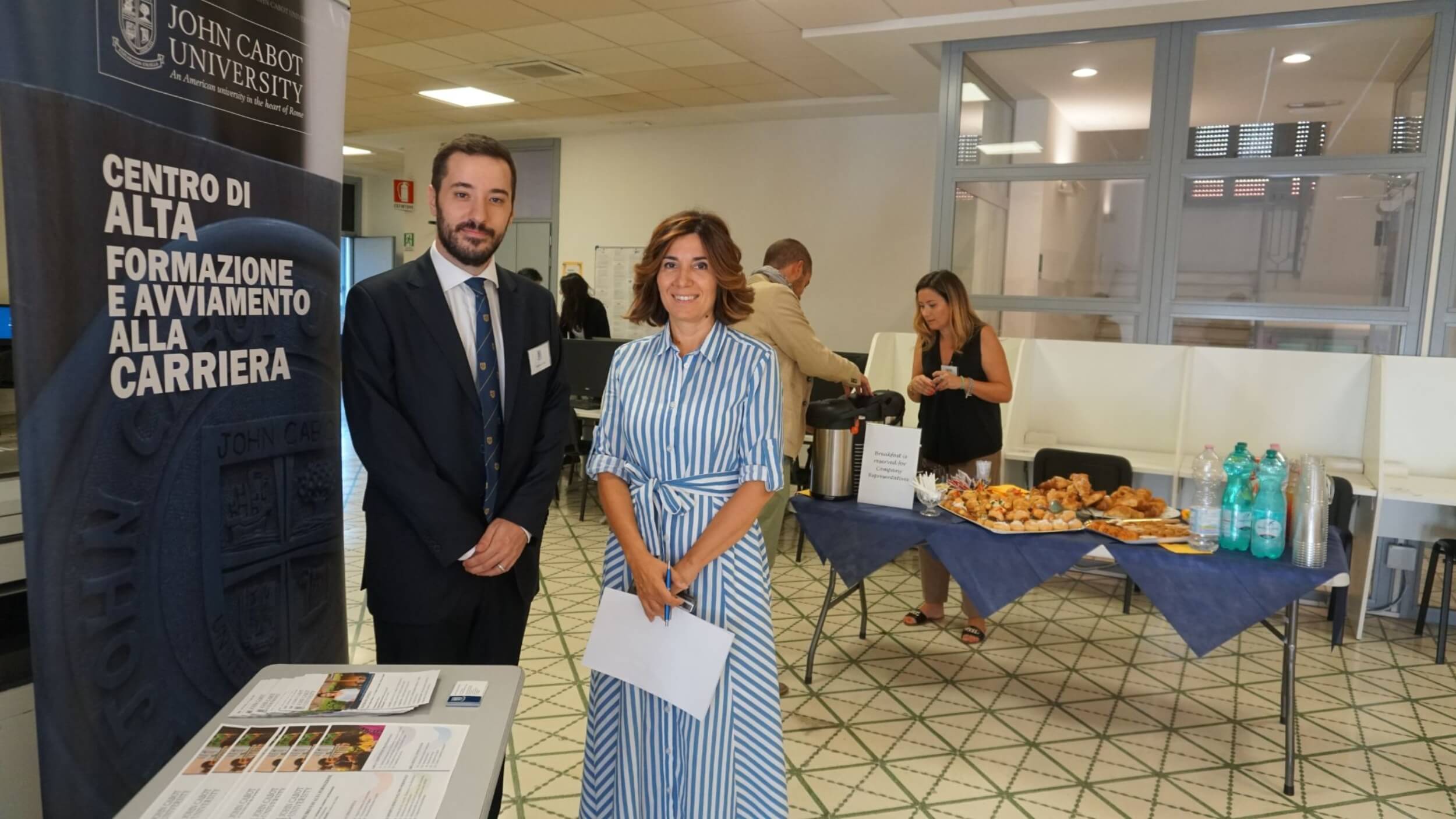 A John Cabot professor posing with a student at an event.