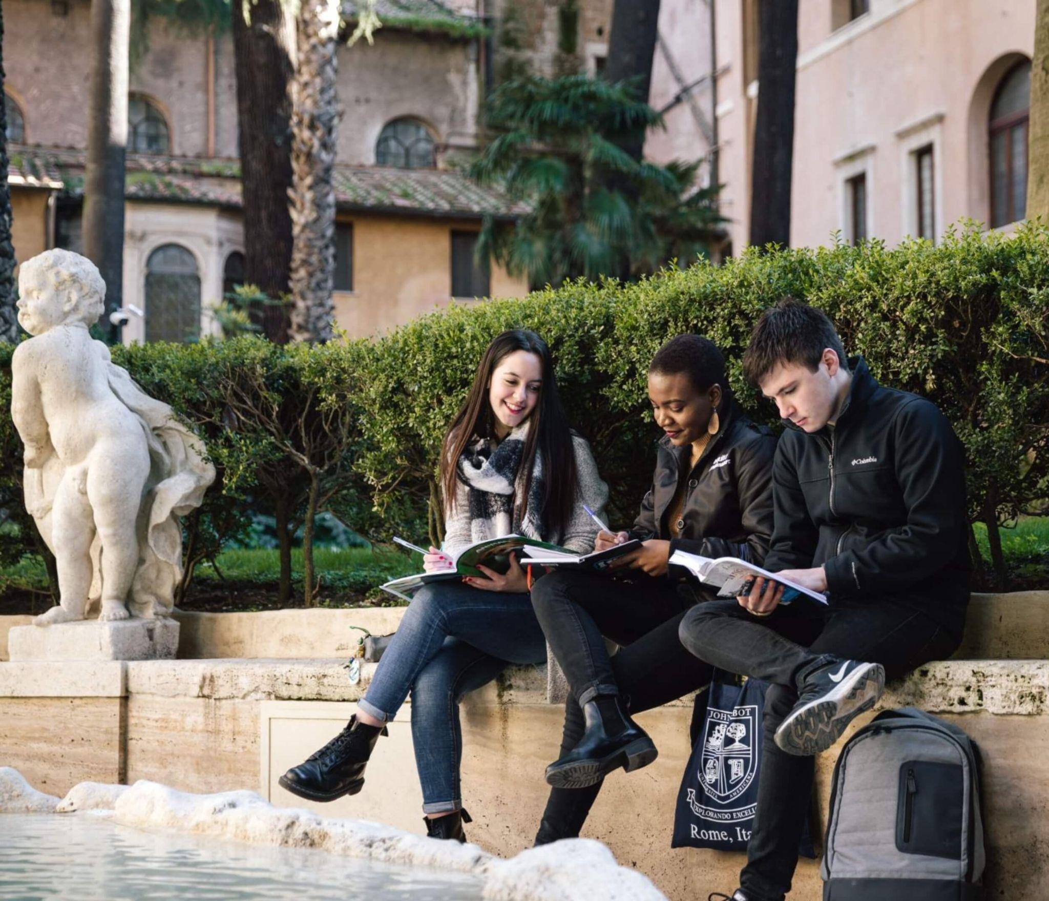 A trio of international affairs students reading outside together