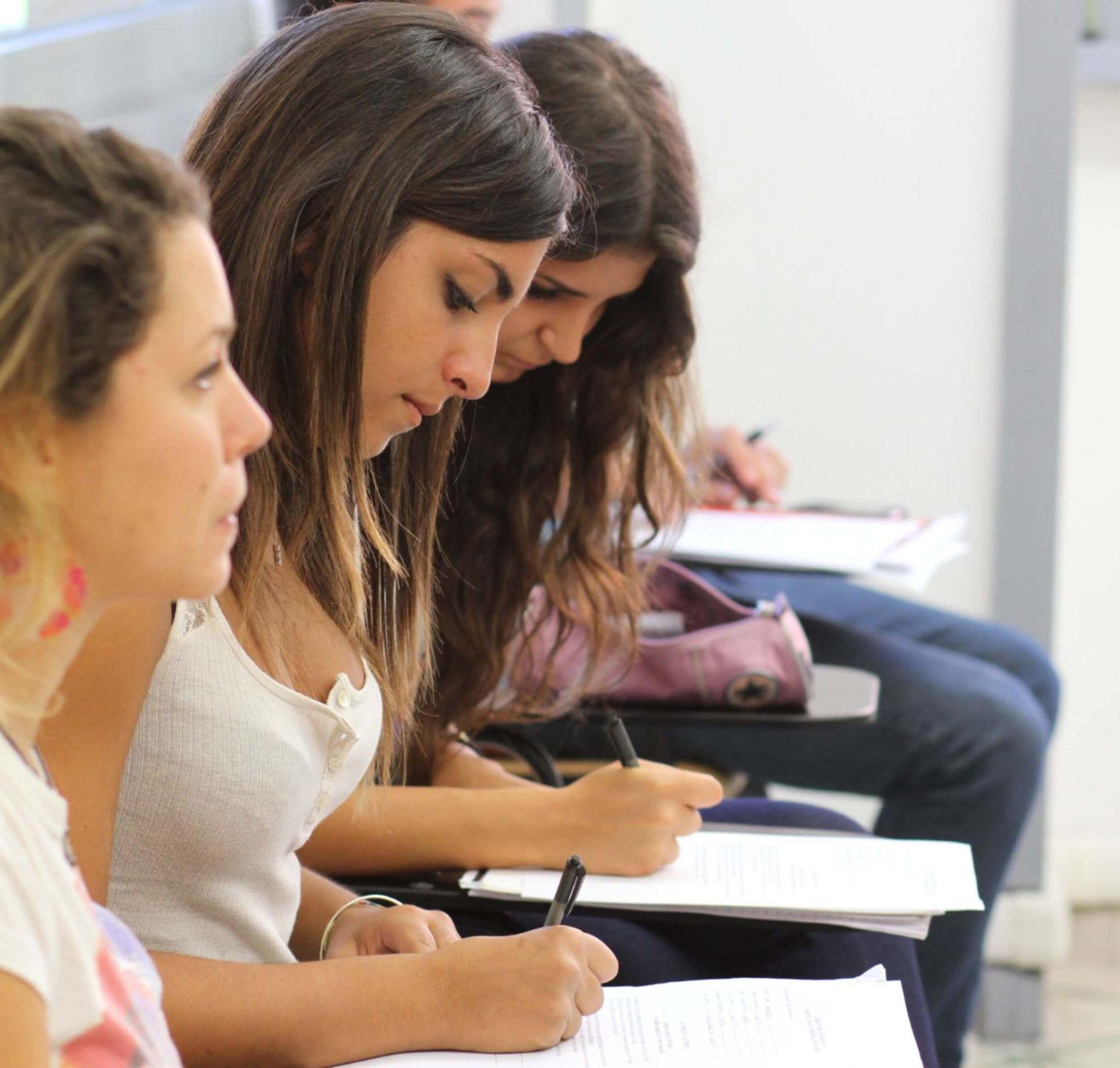 A class of students attending university in Rome working independently in a classroom