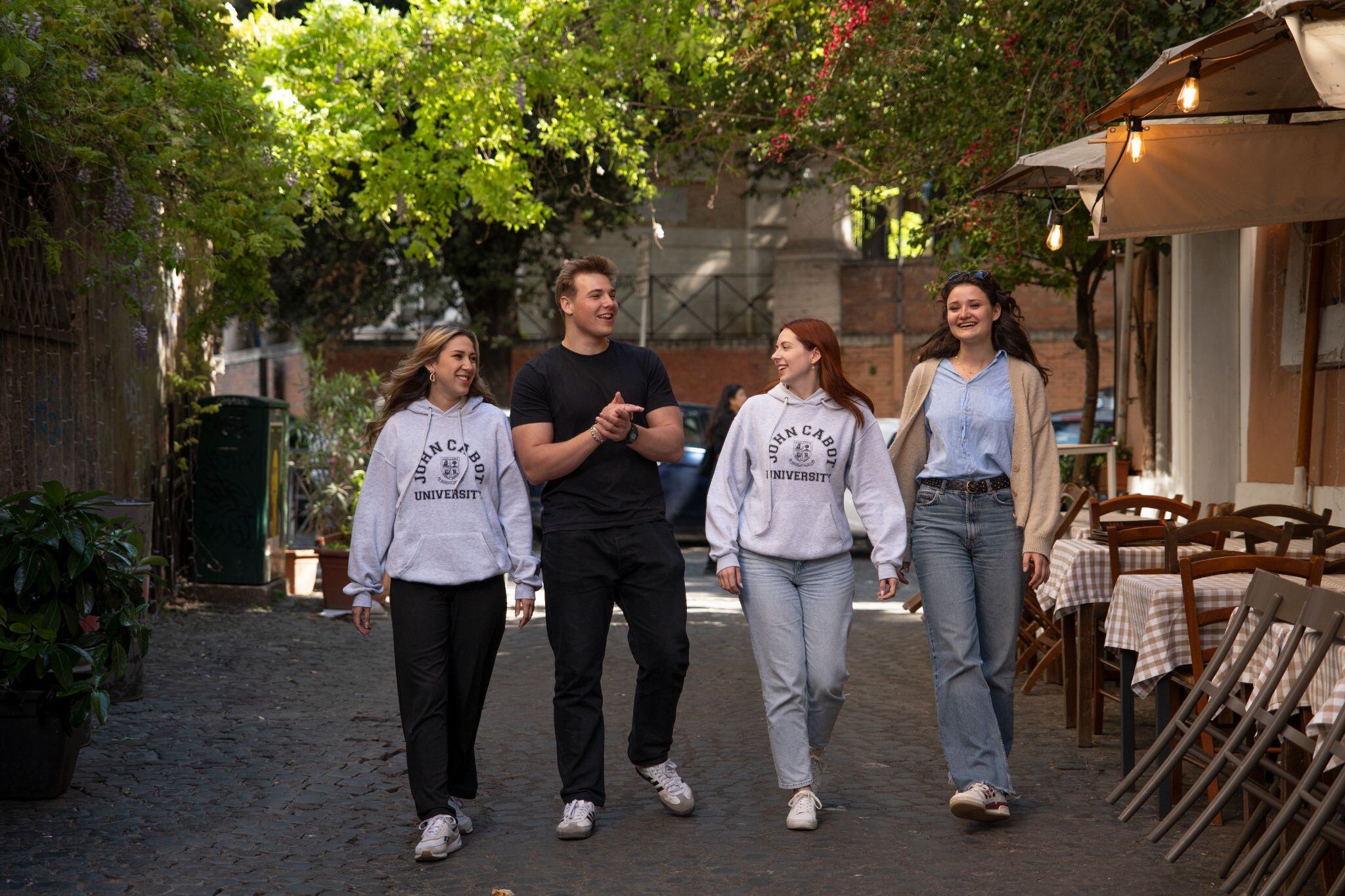 A group of smiling students walking through the streets of Rome while taking full advantage of their study abroad in Italy experience