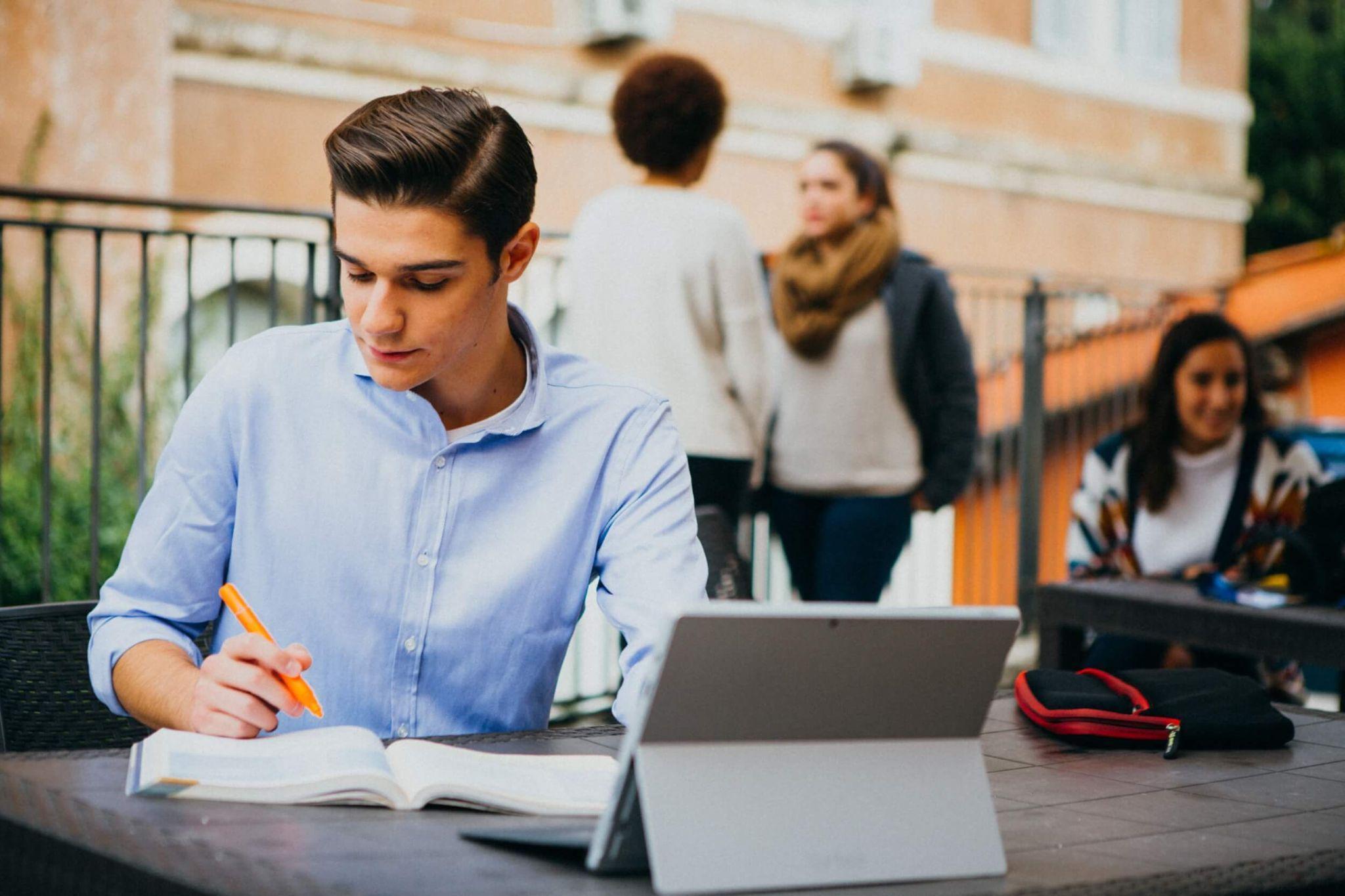 John Cabot student studying outside