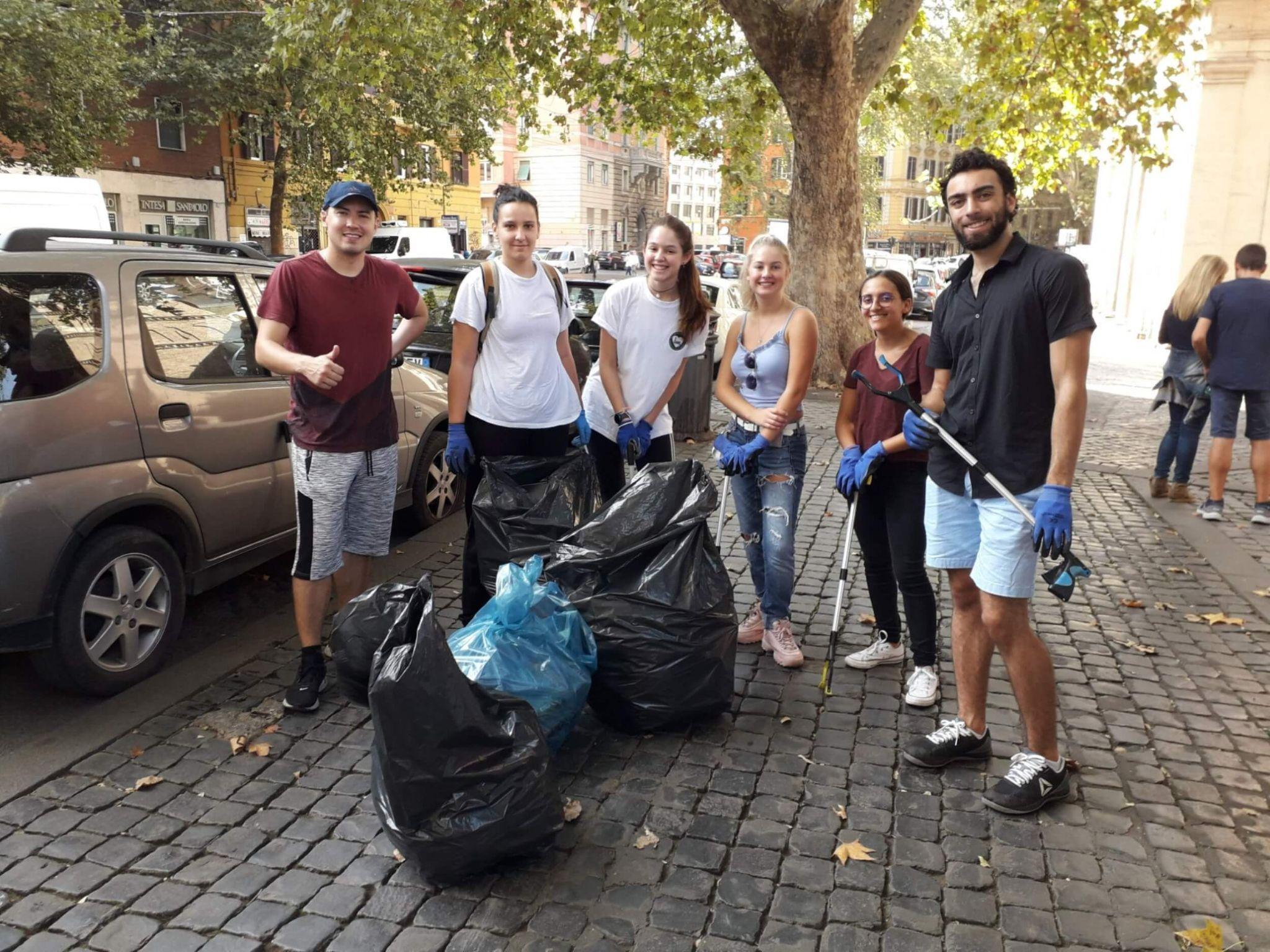 A group of JCU students participating in a garbage pickup on the street.
