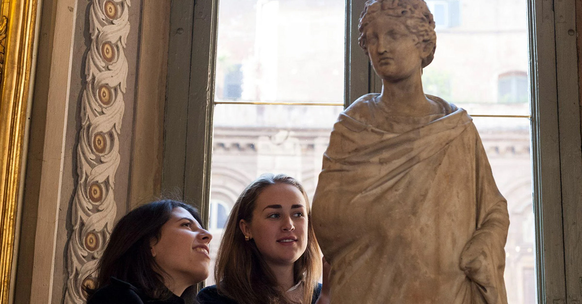student completing an MA in Art History examining a statue