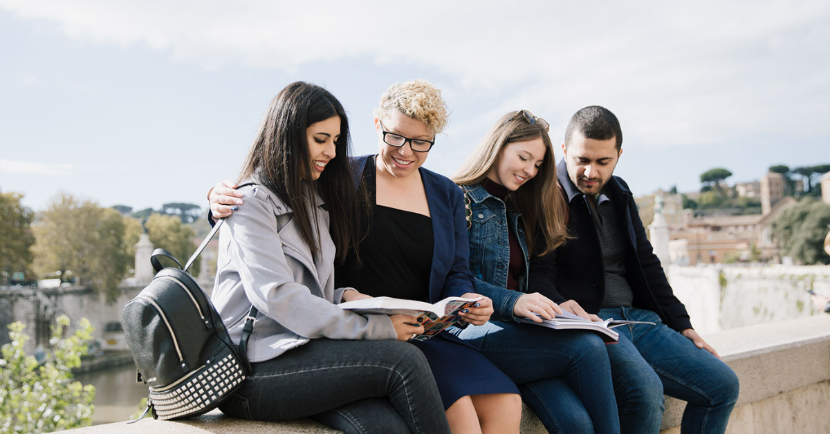 A group of students sitting in a line looking at textbooks