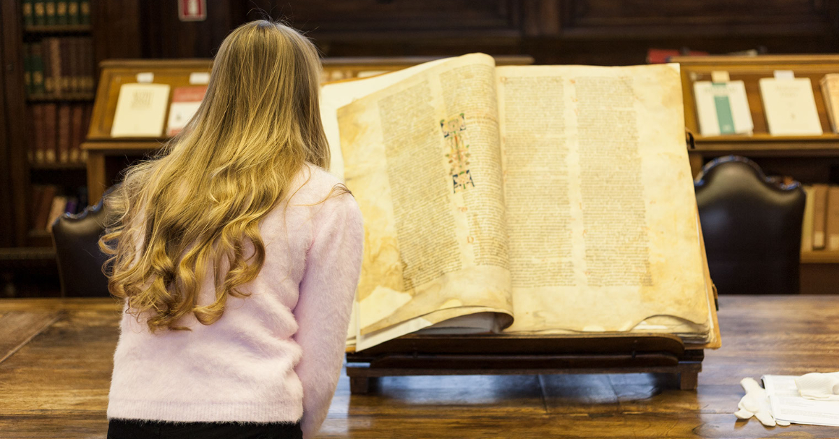 Student looking through a historical and fragile book