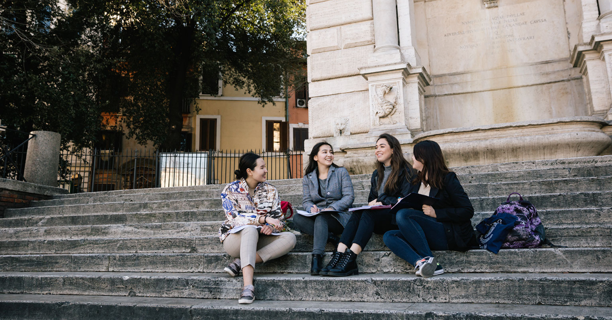 4 smiling girls sitting on stairs