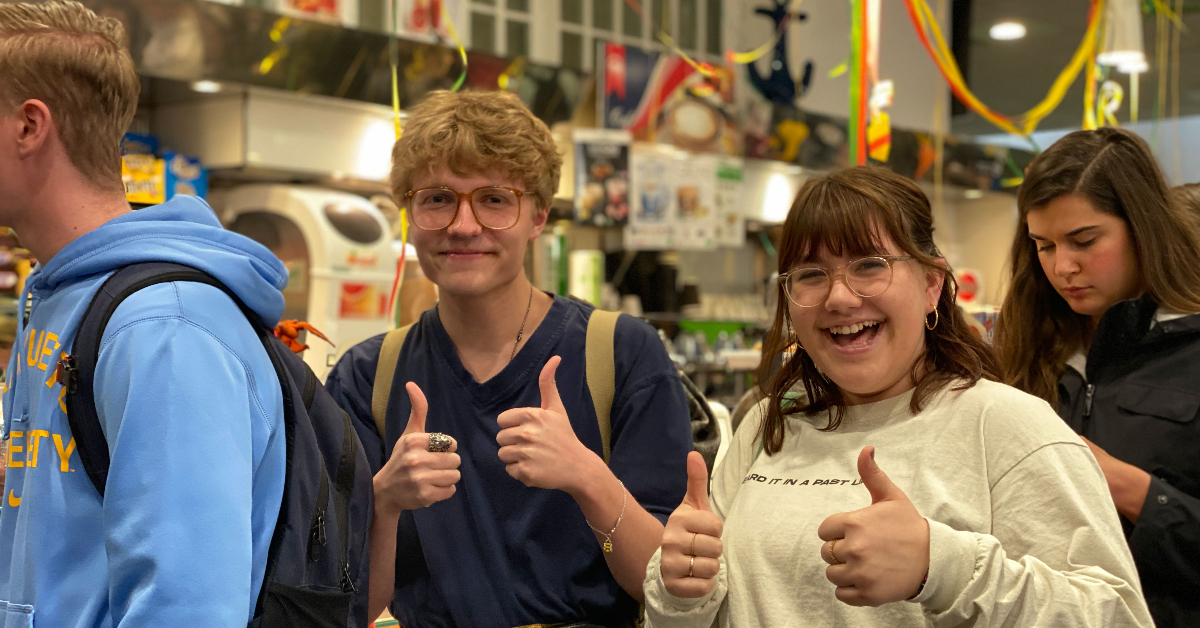 Students holding their thumbs up during Carnevale lunch