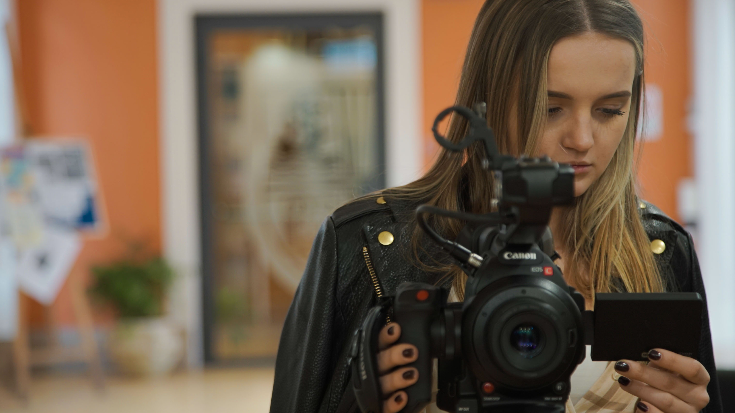 Girl standing with a camera pointed at the viewer