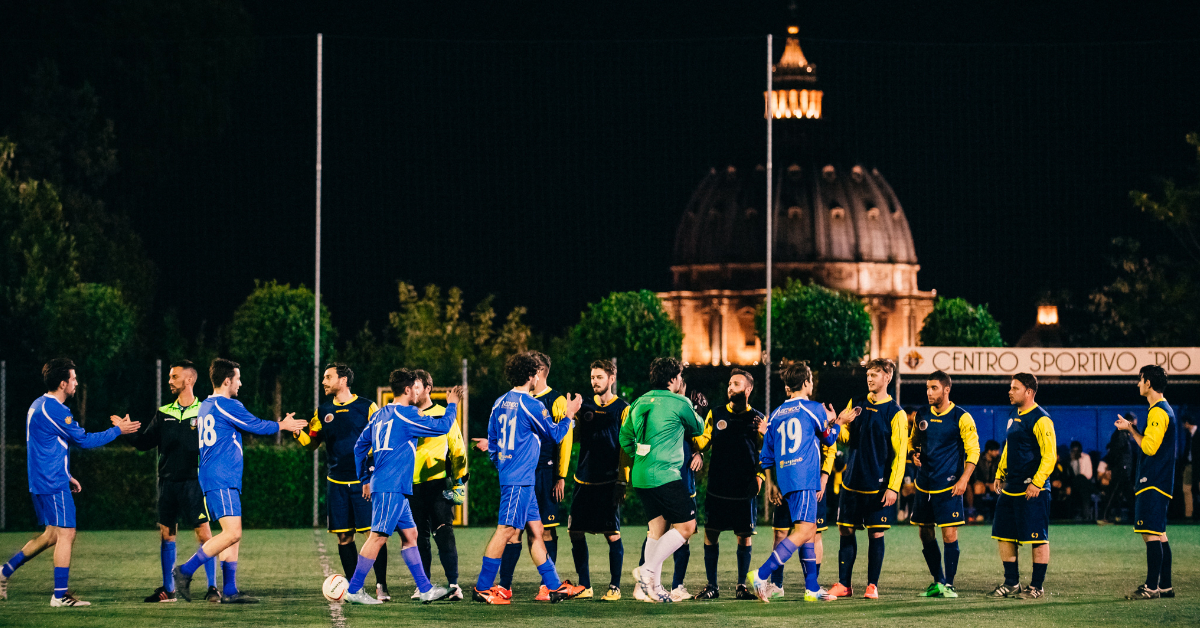 JCU soccer team shaking hands with opponents with the Vatican in the background