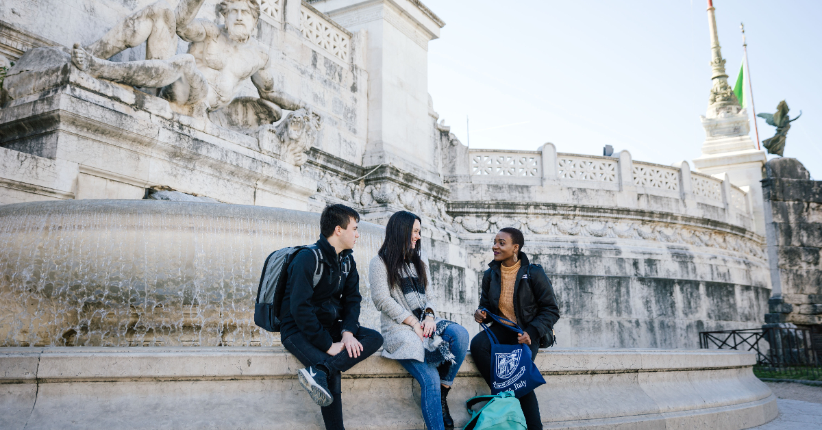 Students chatting in front of a fountain in Rome