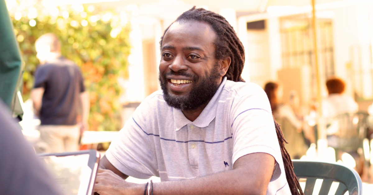 Professor Kwame Phillips sitting and chatting in the courtyard