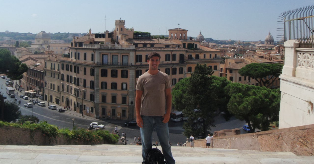 Guy standing center frame on top of steps to Campidoglio 