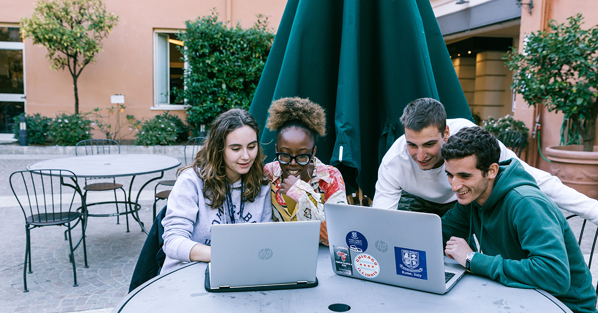 4 John Cabot University students studying together on campus