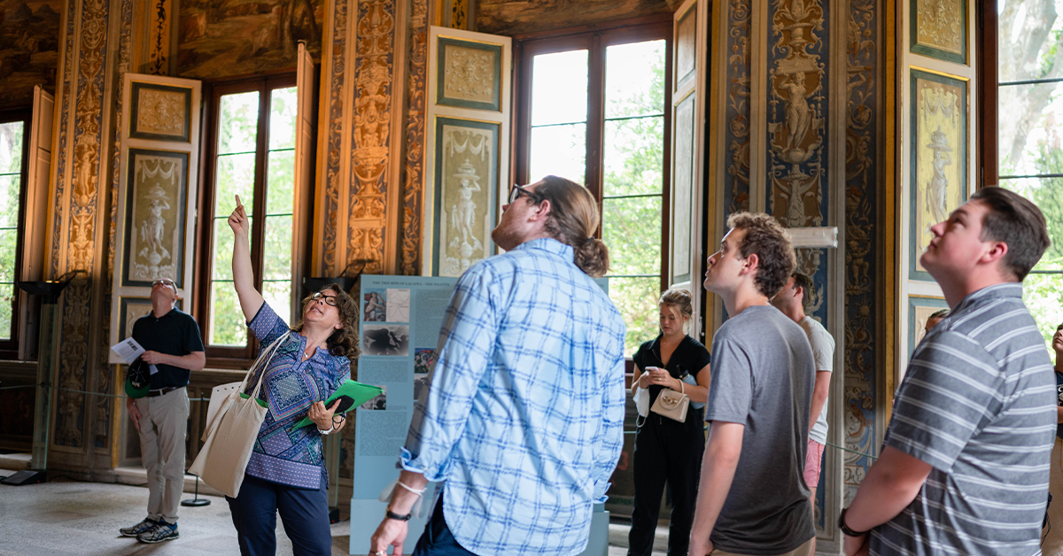 A group of art history degree seekers examining an artifact in a museum